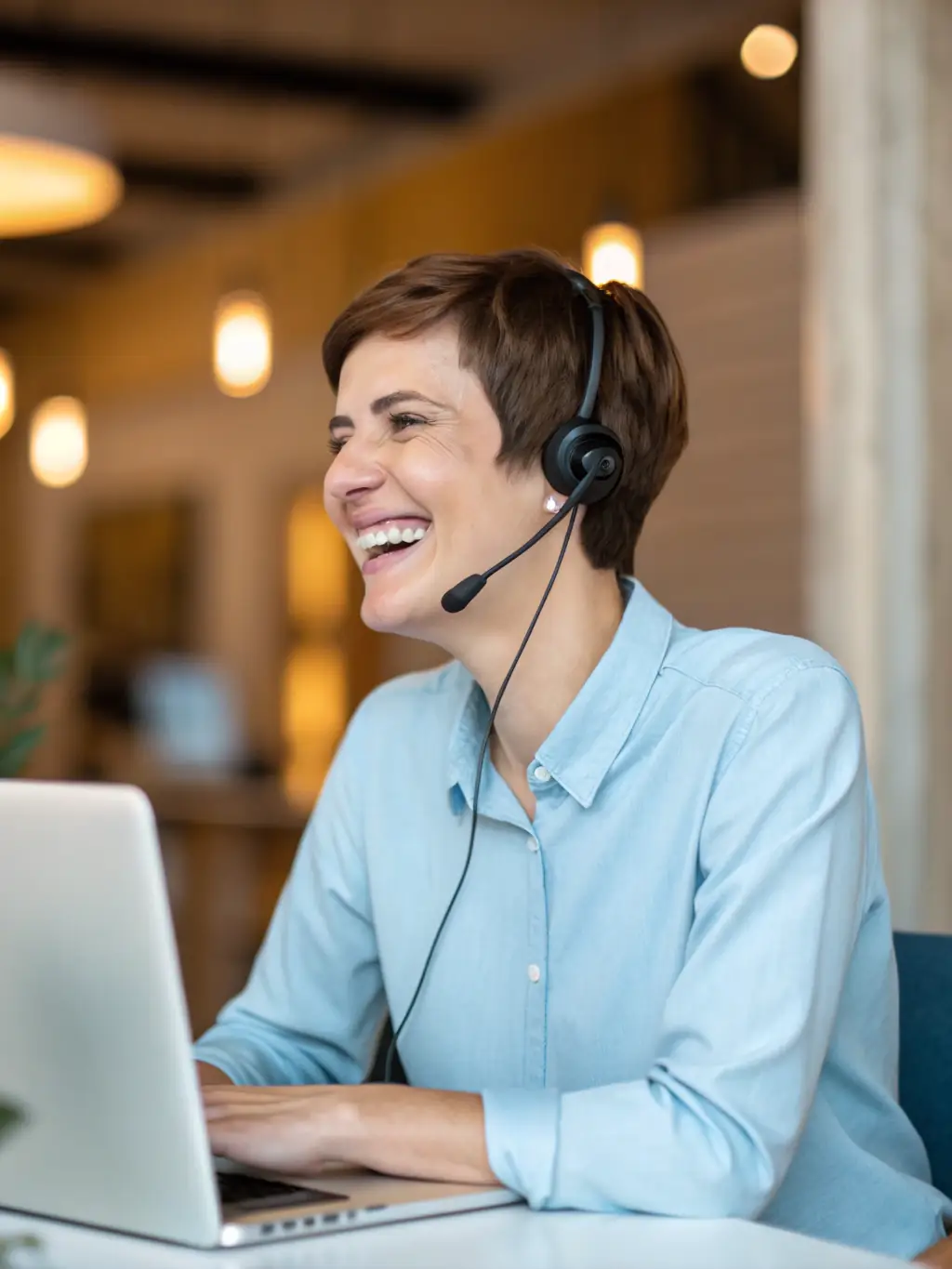 A friendly customer support representative speaking on the phone, with a computer screen showing maintenance schedules and service reminders.
